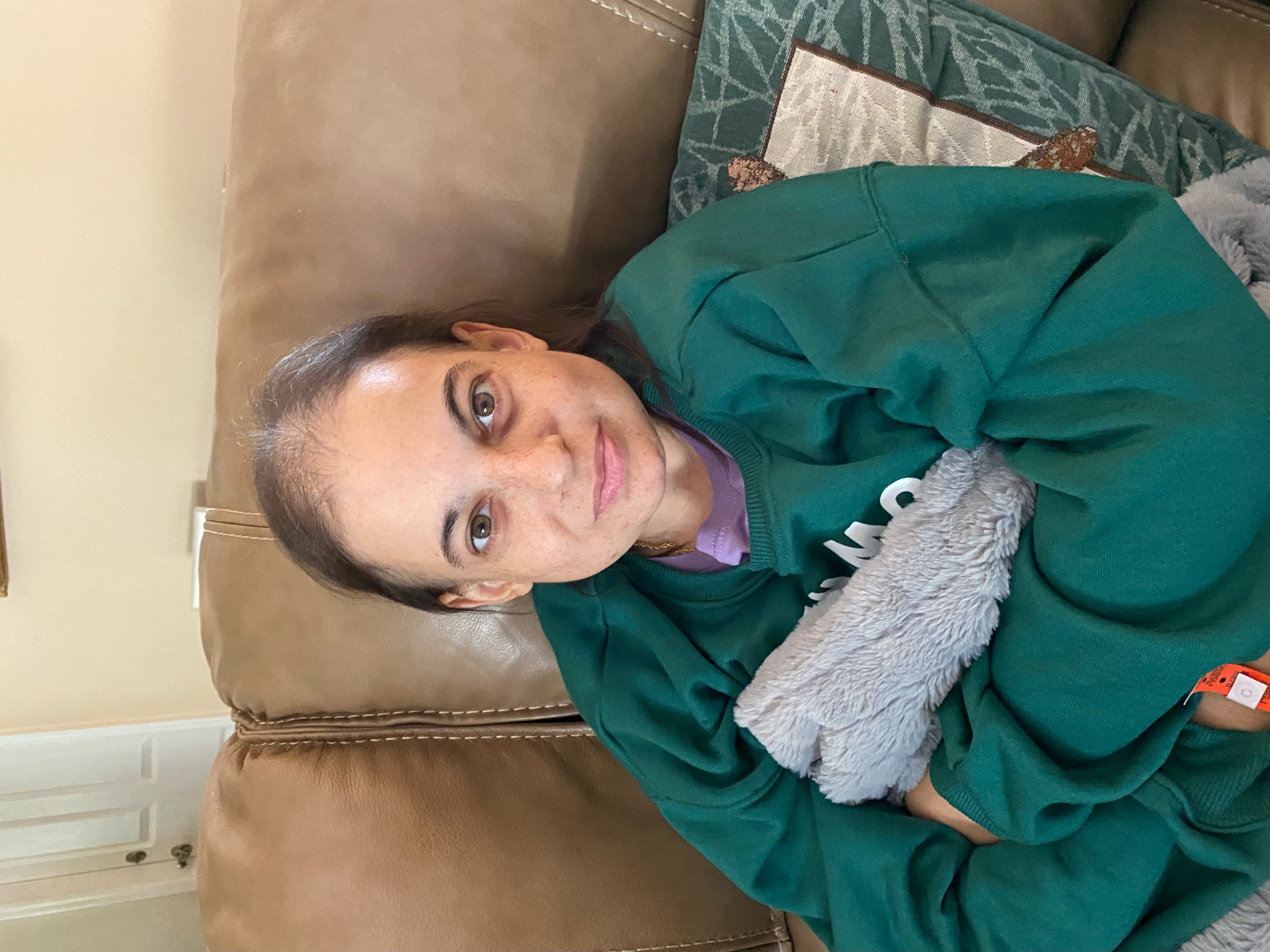 Kelly resting, holding a stuffed animal