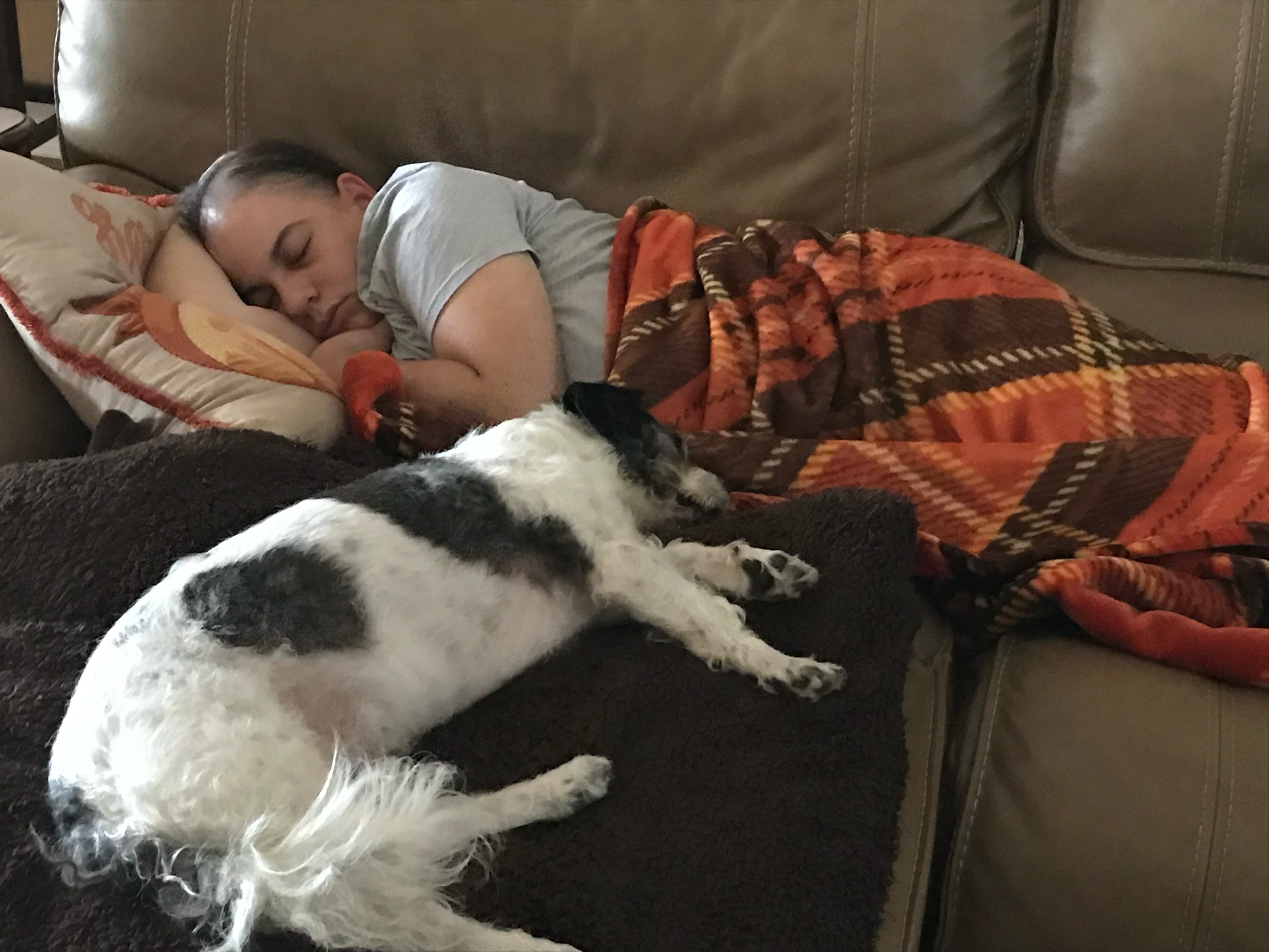 Kelly resting on the couch with her dog